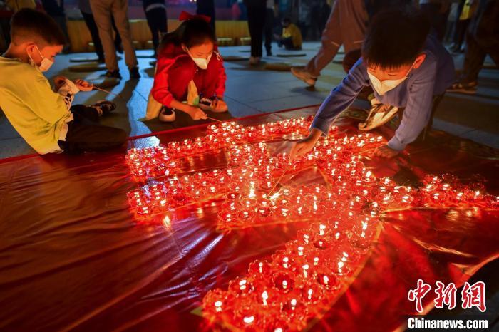 12月31日三亚南山景区，人们点亮蜡烛摆出祝福字语。　骆云飞 摄