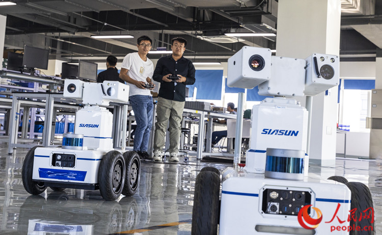 天津新松智能科技有限公司工作人员在调试机器人。人民网记者 孙翼飞摄